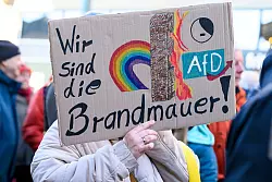 In Frankfurt erinnert eine Demonstrantin an die Brandmauer. - © Salome Roessler/dpa