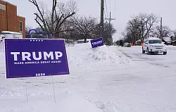 Ein Wahlplakat des ehemaligen US-Präsidenten Trump steht in Des Moines bei eisiger Kälte im Schnee. - © Uncredited/kyodo/dpa