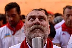 Viele L&auml;ufer halten traditionell eine aufgerollte Zeitung in der Hand, mit der sie w&auml;hrend der Hatz anderen L&auml;ufern Zeichen geben und den Stieren auch leichte Klapse geben k&ouml;nnen, um sie zu dirigieren. - &copy; Alvaro Barrientos/AP