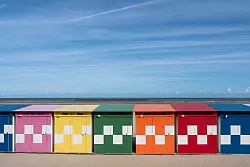 Bunte Strandh&auml;uschen stehen am Meer in Dunkerque, wie D&uuml;nkirchen offiziell auf Franz&ouml;sisch hei&szlig;t. - &copy; Andreas Drouve/dpa-tmn
