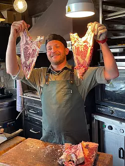 Metzgermeister Matteo Villani grillt auf der Alpino-H&uuml;tte Steaks auf italienische Art. - &copy; Bernhard Krieger/dpa-tmn