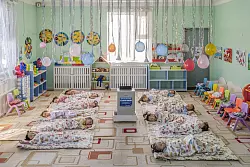 In einem Kindergarten in Ulaanbaatar, der Hauptstadt der Mongolei, liegen Kinder auf dem Boden um einen aufgestellten Luftfilter herum, der die Schadstoffkonzentration senken soll. - &copy; Natalya Saprunova/Unicef/dpa