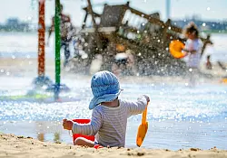Stoff schützt besser. UV-Kleidung mit Schutzfaktor 30 oder mehr ist für Kinderhaut besonders wichtig. - © Ingo Wagner/dpa/dpa-tmn