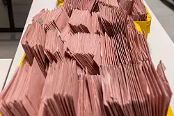 An einem Wahlabend müssen viele Briefwahlunterlagen durchgesehen werden. (Archivbild) - © Helmut Fricke/dpa