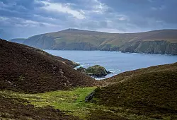 Grüne Hügel, schroffe Felsen, viel Wasser: Die Landschaft der Inseln ist einsam und wild, wie hier im Hermaness Nature Reserve im Norden von Unst. - © Verena Wolff/dpa-tmn
