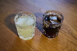 Zwei unterschiedliche Arten Softdrinks mit Eiswürfeln stehen auf einem Tisch - © Annette Riedl/dpa