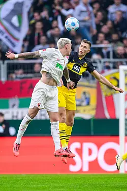 Augsburgs Phillip Tietz (l) und Dortmunds Nico Schlotterbeck im Luftkampf. - &copy; Tom Weller/dpa