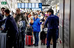 Reisende stehen Schlange am Serviceschalter der Fluggesellschaft KLM am Flughafen Schiphol. - &copy; Robin Utrecht/ANP/dpa
