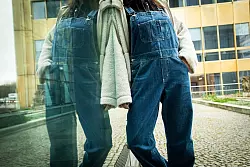 Eine weite, kurze Teddyjacke zur Latzhose bringt Struktur in das Outfit. - © Christin Klose/dpa-tmn