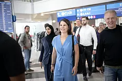 Außenministerin Annalena Baerbock (M, Bündnis 90/Die Grünen) ist auf dem Flughafen in Dubai auf dem Weg zu ihrem Flug. - © Sina Schuldt/dpa