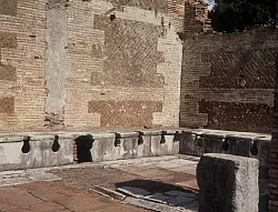 Die alten R&ouml;mer sa&szlig;en oft Schulter an Schulter, um ihr Gesch&auml;ft zu verrichten. (Archivbild) - &copy; Kurt Rohwedder/dpa