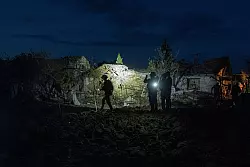 Ukrainische Polizisten dokumentieren die Sch&auml;den an H&auml;usern, die von einem Raketenangriff auf ein Wohnviertel in Pokrowsk getroffen wurden. - &copy; Evgeniy Maloletka/AP