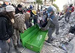 Helfer bergen ein Todesopfer. - &copy; Boris Roessler/dpa