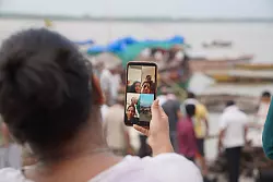 Eine Frau zeigt ihren Angeh&ouml;rigen, die nicht anwesend sein k&ouml;nnen, in einem Videoanruf das Verbrennungsritual eines verstorbenen Familienmitglieds. - &copy; Anne-Sophie Galli/dpa