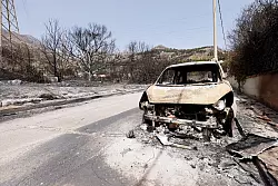 Ein vom Feuer zerst&ouml;rtes Auto auf einer Landstra&szlig;e auf Sizilien. - &copy; Alberto Lo Bianco/LaPresse via ZUMA Press/dpa