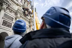 Die riesige Kartusche mit Wappen wird &uuml;ber dem Eosander-Portal, dem Haupteingang der rekonstruierten barocken Schlossfassade, mit Hilfe von Kran und Fassadenkletterern angebracht. - &copy; Hannes P. Albert/dpa