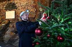 Schmücken, auch unter Tage: Gunnar Lenhard und Weihnachtsbaum im Markus-Röhling-Stolln. - © Hendrik Schmidt/dpa