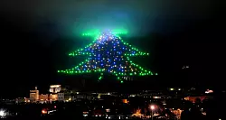 Der Baum so groß wie ein Berg: Eine 750 Meter hohe Lichtinstallation mit Hunderten Leuchtpunkten erstrahlt im Dezember 2009 am Berghang im italienischen Gubbio. (Archivbild) - © Pietro Crocchioni/epa/ANSA/dpa