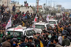 Hunderte Schaulustige verfolgten die Geisel-Übergabe an Vertreter des Roten Kreuzes vor Ort. - © Abdel Kareem Hana/AP/dpa