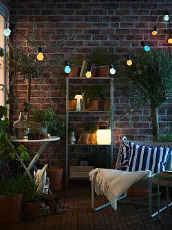 Stimmungsvoll: Mit Outdoor-Leuchten und Lichterketten (hier von Ikea) kann man den Balkon schnell in ein lauschiges Plätzchen verwandeln. - © IKEA Systems B.V. 2025/dpa-tmn