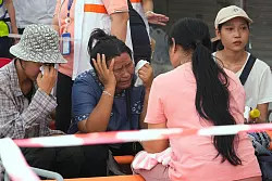 Vor dem eingestürzten Hochhaus in Bangkok warteten Menschen auf Neuigkeiten über ihre Angehörigen. - © Manish Swarup/AP/dpa