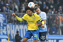 Im Kopfballduell: Sidi Sane (l) von Eintracht Braunschweig und Bochums Noah Loosli. - &copy; Swen Pf&ouml;rtner/dpa