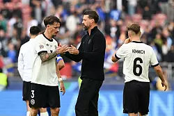 Servus Jungs: Sandro Wagner klatscht nach seinem letzten Länderspiel als Co-Trainer mit Robin Koch (l) ab. Rechts Kapitän Joshua Kimmich. - © Federico Gambarini/dpa