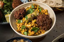 Bulgur wird ähnlich wie Reis gekocht und schmeckt zum Beispiel gut in einem Salat - hier mit weißen Bohnen, Petersilie, Oliven und Köfte. - © Christin Klose/dpa-tmn