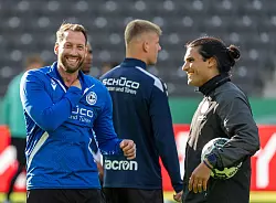 Arminia-Coach Mitch Kniat (l) geht mit bester Laune ins Pokalfinale. - © Soeren Stache/dpa