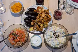 Estnische Wintergerichte: Blutwurst aus dem Ofen (M), dazu Sauerkrautsalat mit Lachs (l. u.) und Kartoffelsalat mit Sour Cream (r. u.). - &copy; Andreas Drouve/dpa-tmn