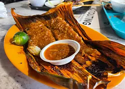 Echte Spezis: Viele St&auml;nde im Lau Pau Sat konzentrieren sich auf gegrillten Stachelrochen in Bananenbl&auml;ttern. - &copy; Manuel Meyer/dpa-tmn