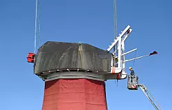 Mit einem Autokran wurde die tonnenschwere Kappe wieder auf die M&uuml;hle gesetzt. - &copy; Lars Penning/dpa