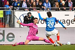 Kiels Knudsen (r) scheitert bei einer der wenigen Holstein-Chancen gegen Leverkusens Torhüter Matej Kovar. - © Gregor Fischer/dpa