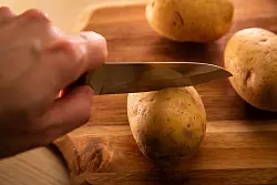 Schritt 1: Die Kartoffeln rundherum mit dem Messer vorsichtig einschneiden. - © Christin Klose/dpa-tmn