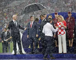 Bei der Siegerehrung 2018 steht Gianni Infantino (l.) neben Russlands Pr&auml;sident Wladimir Putin im Regen. (Archivbild) - &copy; Matthias Schrader/AP/dpa