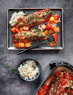 Rote Spitzpaprika werden mit einem Mix aus Zwiebeln, Knoblauch, Feta, Hackfleisch, Chiliflocken, Ei, Panko und etwas Salz und Pfeffer gefüllt, kommen dann für 15 Minuten in den Airfryer. Fünf Minuten vor Ende kommt die Soße aus Tomaten und Sahne dazu. - © Hubertus Schüler/Becker Joest Volk Verlag/dpa-tmn