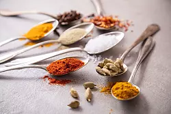 Wer gerne asiatische oder orientalische Noten in Speisen bringt, sollte neben Nelken, Chili-Flocken, weißem Pfeffer, Salz und Paprikapulver auch Kardamom, Currypulver und Kurkuma im Hause haben. - © Christin Klose/dpa-tmn