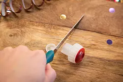 Schritt 1: Die Unterseite des Korkens mit einem Messer abschneiden. - &copy; Christin Klose/dpa-tmn