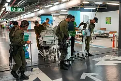 Krankenhauspersonal und Soldaten bringen Patienten und Ausrüstung in die unterirdische Station der Rambam-Klinik. - © Ohad Zwigenberg/AP/dpa