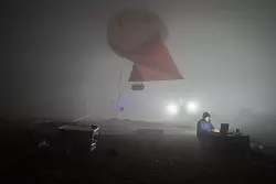 Michael Lonardi mit einem Wetterballon in dichtem Nebel auf dem Berg Helmos in Griechenland. - © Lionel Favre/Nature/dpa