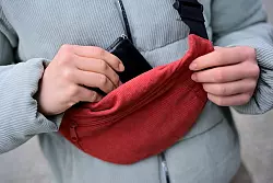 Cord lässt sich im Alltag wieder öfter antreffen; Eine Frau trägt eine Jacke und eine Brusttasche aus Cord und steckt ihr Portemonnaie in die Tasche. (Foto: Illustration) - © Sebastian Gollnow/dpa