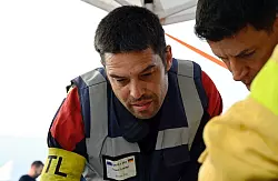 Simon Friz (links), Teamleiter der insgesamt 67 Feuerwehrleute aus Bonn, Düsseldorf und Celle, die bei der Bekämpfung schwerer Waldbrände in Spanien geholfen haben, bei einer Einsatzbesprechung. Für die Deutschen ging es auch darum, das Wissen ihrer südeuropäischen Kollegen mit nach Deutschland zu nehmen. (Archivbild) - © Sven Käuler/dpa