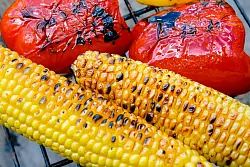 Frischer Mais sollte vor dem Grillen 10 Minuten in kochendem Wasser vorgegart werden. Auf dem Grillrost brutzelt er dann noch weitere 10 Minuten. Dabei öfter umdrehen. - © Markus Scholz/dpa-tmn