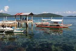 Kaum Betriebsamkeit zu spüren: Boote liegen im Wasser von Culion. - © Andreas Drouve/dpa-tmn