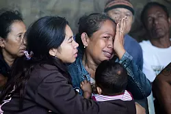 Viele Familien warteten verzweifelt auf Nachrichten. - © Firdia Lisnawati/AP/dpa