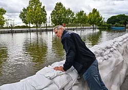 Wie schlimm wird das Hochwasser? Frank Balzer (SPD), der B&uuml;rgermeister von Eisenh&uuml;ttenstadt, blickt &uuml;ber einen Wall aus Sands&auml;cken im Stadtteil F&uuml;rstenberg, wo Stra&szlig;en &uuml;berflutet wurden. - &copy; Patrick Pleul/dpa