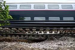 Dieser Zug musste anhalten, weil der Schotter unter den Schienen nach heftigen Regenfällen wegbrach. - © Christophe Archambault/AFP/dpa