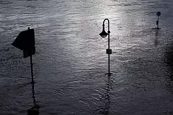 Verkehrsschilder und eine Stra&szlig;enlaterne am &uuml;berfluteten Weserufer in Minden. - &copy; Friso Gentsch/dpa