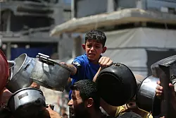 Kinder im Gazastreifen warten auf warmes Essen. - © Omar Ashtawy/APA Images via ZUMA Press Wire/dpa