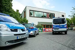 Polizeiautos stehen vor einer Schule in Spandau, an der es einen Messerangriff auf eine Schüler gab. - © Jörg Carstensen/dpa
